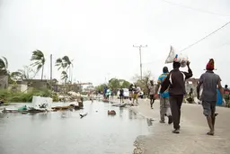 People walk on a flooded road