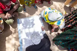 People draw a map on a large piece of paper on the ground