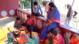Men and women gathered to look at a laptop 