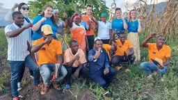 A group of young people with their hands up posing for a picture