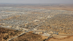 An aerial view of a refugee camp, with housig stretching over a vast area in the desert.