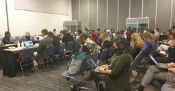 Room full of people sitting down and looking at their laptops