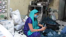 Woman wearing a face mask sits on the floor and handles tools