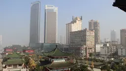 View of a city with traditional housing and two skyscraper in the distant background