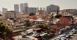 A city street filled with lots of traffic next to tall buildings.