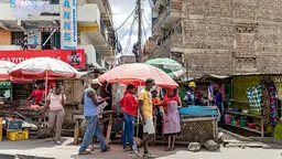People standing and walking on a street with informal stalls