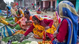 Vegetables street vendors sitting on the floor.