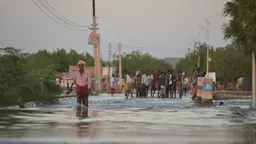 Man walking on a flooded  road.