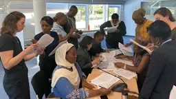 A group of people gathered around a table with papers.