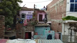People put out washing on a line on top of a house 