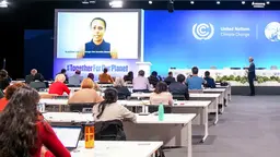 A conference room with people sitting at tables.
