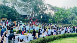 A diverse crowd of individuals congregated in a park, engaging in various activities.