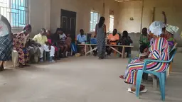 A group of individuals sitting in chairs, engaged in a discussion.