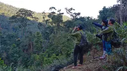 Two men surveying a hilly landscape.