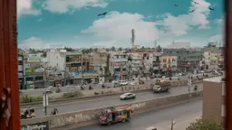 A busy city street with several vehicles on the road and building on the back.