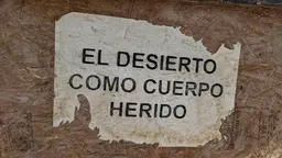 A sign with the words "El desierto como cuerpo herido"
