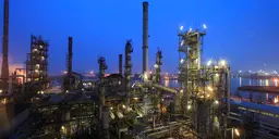 A refinery under a clear blue night sky. 