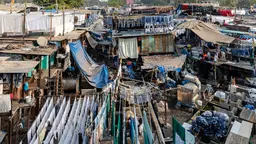 Open air laundry place in Mumbai, clothes and pieces of material hanging on strings and air drying.