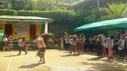 Women racing while carrying baskets full of sweet potatoes on their backs.
