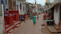 Image showing the fishing community slum of Sai Baba Sahi after the construction, with a main street paved with stones, houses and shops. 