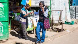 Two men shaking hands as they pass each other on the streets of Nairobi, Kenya.