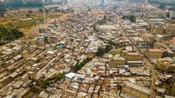 An aerial view showing thousands of iron roofs packed closely together, with few green spaces.