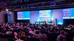 Panel discussion during the opening plenary of the London Climate Resilience Finance Summit 2026. Four speakers are standing on stage while the audience watches. A big screen is projecting the summit logo on the background.