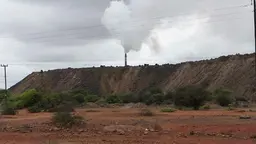 A chimney stack in the distance pours out smoke.