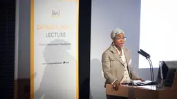 A woman stands at a podium giving a speech.