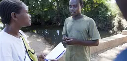 A researcher speaks to a cotton farmer in Mozambique. 