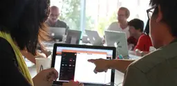 People point to a computer screen. 
