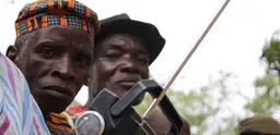 Men in Cote d'Ivoire listen to a radio. 