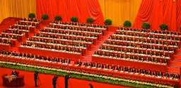 The Central Committee of the Chinese Communist Party in the Great Hall of the People, uniformed in identical suits, red ties, and side-parts. 