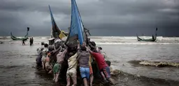 Fishing boats return to a beach on the Bay of Bengal. 