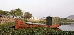 Boat surrounded by vegetation growing in the water near the river port of Vallemi.