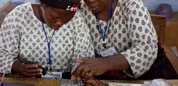 Women working together to build a solar lighting circuit board. 