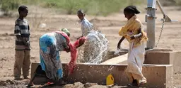 Ethiopian children play in the water of a well 
