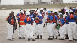 Extractive industry workers are pictured on a beach; a new report recommends that transparency initiatives need to be more inclusive and relevant to local needs for communities most affected by oil, gas or mining projects (Photo: iStockphoto.com/Getty Images)