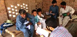 Researchers talk to villagers in Sheikhuwal village in rural Pakistan