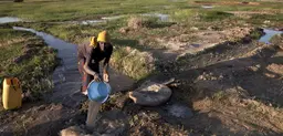 Timbuktu, Mali: A woman pours water from an irrigation canal onto her garden. Mali's climate-resilient agricultural plan will promote better irrigation systems (Photo: Marco Dormino/MINUSMA)