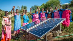 A community-based green energy project: Sinteyo and the women's group with solar panels at the greenhouse in Isiolo, Kenya (Photo: Annie Bungeroth/CAFOD)