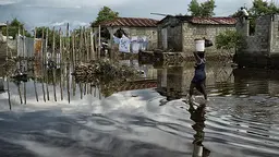 A women carries supplies through a flooded street in Cap-Haïtien, Haiti, after thousands were displaced following floods in 2014. Studies have shown that, when they are socially or economically disadvantaged, more women die in hurricanes and floods (Photo: United Nations Photo, Creative Comms via Flickr)