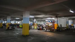 Relocated street vendors operate in the car park below the alun-alun of the Masjid Raya Mosque in Bandung, but this basement area does not attract many customers and vendors have to breathe in car and motorcycle fumes due to the poor air circulation (Photo: Kemal Jufri/Panos Pictures)