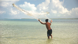 An image of an artisanal fisher in Kiribati casting his net into the water; 90 per cent of all fishers are small-scale or artisanal (Photo: Quentin Hanich/WorldFish, Creative Commons, via Flickr)