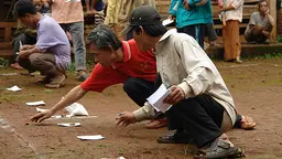 An image of crouching community members in a village in Champasak province, Laos identify areas where open defecation is taking place ahead of implementing sanitation measures (Photo: Viengsompasong Inthavong/World Bank, Creative Commons, via Flickr)