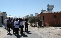 People visiting a village with solar panels