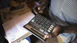 A merchant calculates costs in Geita District, Tanzania (Photo: Brian Sokol/Panos Pictures)