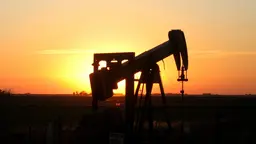 An oil rig silhouetted at sunset