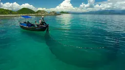 A fisher waits with a large net attached to his small boat