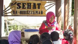 A cook serves food to a group of children